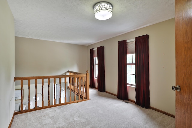 587 Center Woods Dr, Columbus, OH 43214 - hall with carpet floors, a textured ceiling, baseboards, and an upstairs landing