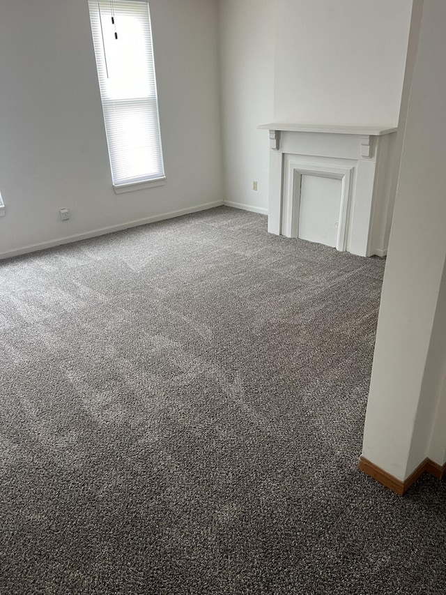 65 E N St, Newark, OH 43055 - unfurnished living room featuring carpet floors and baseboards
