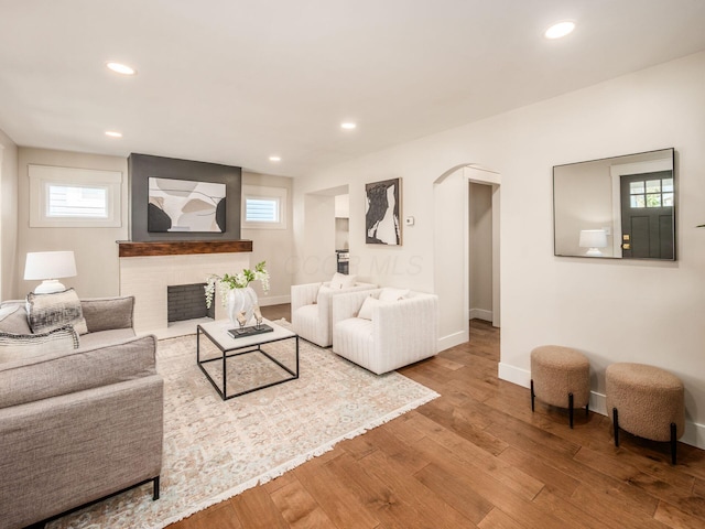 697 Stanley Ave, Columbus, OH 43206 - living area featuring arched walkways, wood finished floors, baseboards, recessed lighting, and a brick fireplace