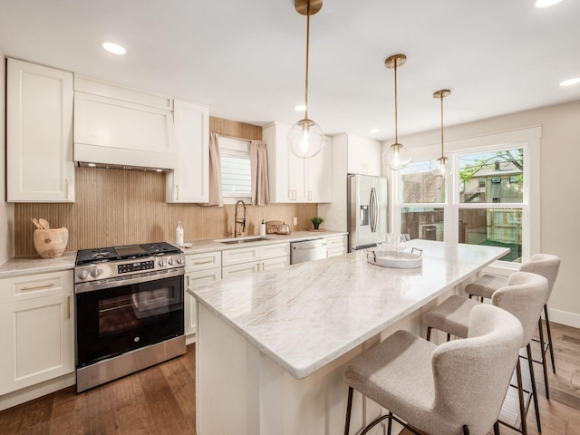 697 Stanley Ave, Columbus, OH 43206 - kitchen with stainless steel appliances, custom exhaust hood, a sink, a center island, and backsplash