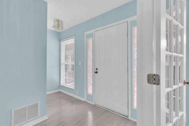 foyer featuring wood finished floors and baseboards