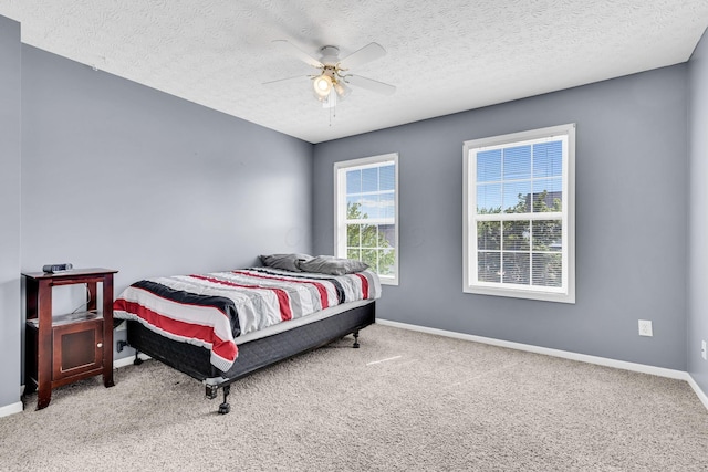 bedroom featuring baseboards, carpet, and a textured ceiling