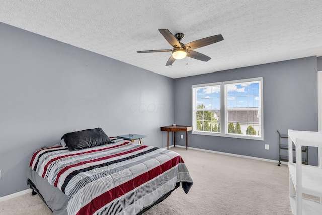 carpeted bedroom with baseboards, ceiling fan, and a textured ceiling