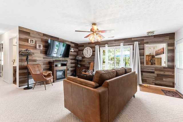 4642 Hobson Dr Unit 13E, Columbus, OH 43228 - carpeted living area with wooden walls, a ceiling fan, a glass covered fireplace, and a textured ceiling