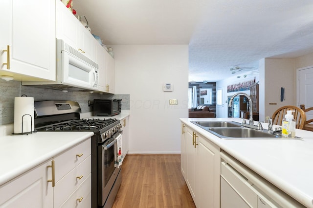 4642 Hobson Dr Unit 13E, Columbus, OH 43228 - kitchen with gas range, white microwave, a sink, dishwasher, and light wood-type flooring