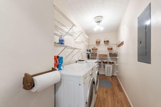 4642 Hobson Dr Unit 13E, Columbus, OH 43228 - clothes washing area with washing machine and clothes dryer, electric panel, light wood-style floors, baseboards, and a textured ceiling