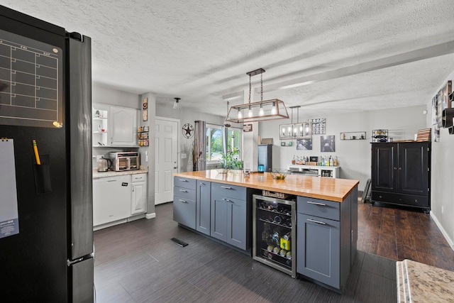 2923 Falcon Bridge Dr, Columbus, OH 43232 - kitchen featuring butcher block counters, beverage cooler, a textured ceiling, pendant lighting, and white cabinetry