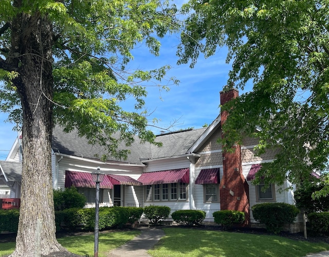 130 N 4th St, Greenfield, OH 45123 - view of front of property with a front lawn, roof with shingles, and a chimney