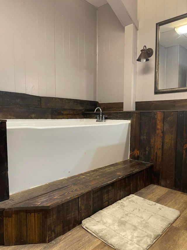 130 N 4th St, Greenfield, OH 45123 - full bathroom featuring a freestanding tub, wood finished floors, and wooden walls