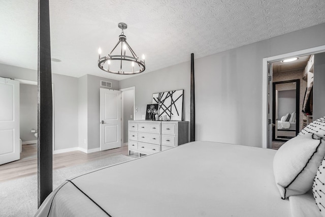 7834 Avaleen Cir N, Dublin, OH 43016 - bedroom with light wood-style floors, a chandelier, baseboards, and a textured ceiling