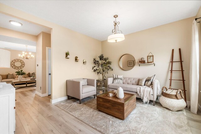 7834 Avaleen Cir N, Dublin, OH 43016 - living room featuring light wood-type flooring, a chandelier, and baseboards