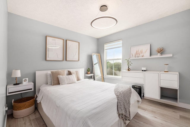 7834 Avaleen Cir N, Dublin, OH 43016 - bedroom with light wood finished floors, a textured ceiling, and baseboards