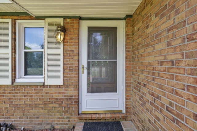entrance to property featuring brick siding