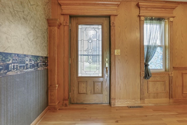 foyer entrance with light wood-style flooring, wallpapered walls, and healthy amount of natural light