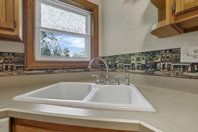 kitchen with a sink, brown cabinetry, and light countertops