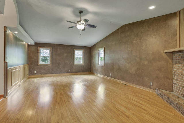 unfurnished living room featuring a ceiling fan, light wood-type flooring, plenty of natural light, lofted ceiling, and recessed lighting