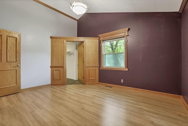unfurnished bedroom featuring light wood-type flooring, high vaulted ceiling, and baseboards