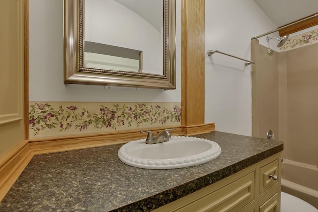 bathroom featuring vanity, washtub / shower combination, and toilet