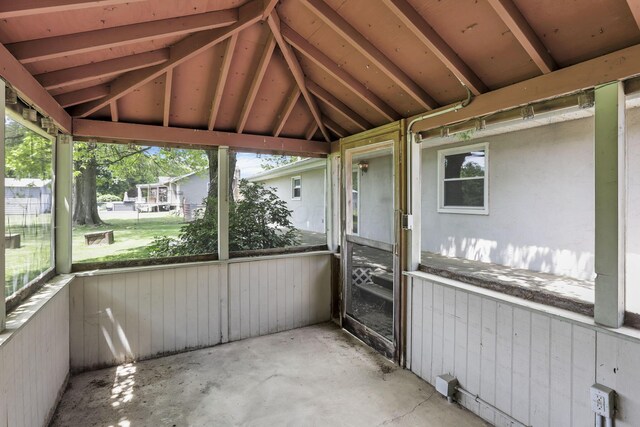 unfurnished sunroom with healthy amount of natural light and vaulted ceiling
