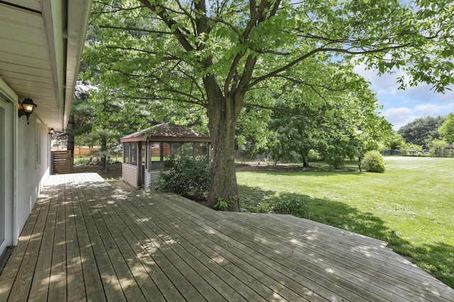 deck featuring a yard and view of wooded area