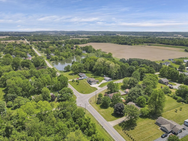 drone / aerial view of a nearby body of water and a tree filled landscape