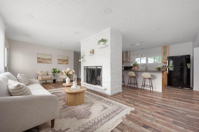 1366 Dyer Rd, Grove City, OH 43123 - living room featuring wood finished floors, a textured ceiling, and a brick fireplace