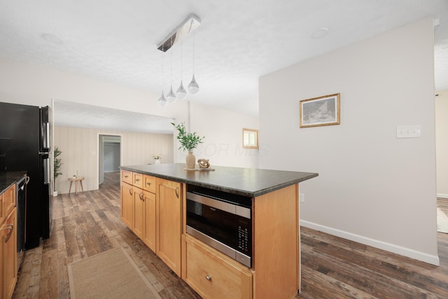 1366 Dyer Rd, Grove City, OH 43123 - kitchen with stainless steel microwave, freestanding refrigerator, dark countertops, dark wood-style flooring, and a textured ceiling