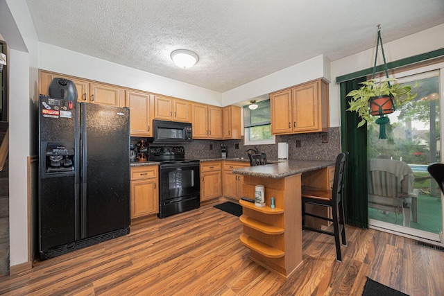 5965 Lucky Charm Dr, Galloway, OH 43119 - kitchen with black appliances, dark countertops, open shelves, wood finished floors, and decorative backsplash