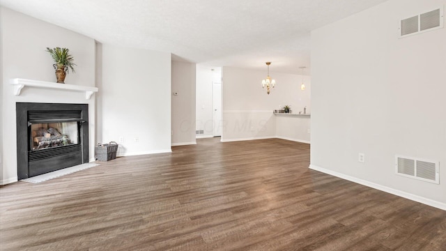 6706 Axtel Dr Unit 7A, Canal Winchester, OH 43110 - unfurnished living room featuring a chandelier, a fireplace with flush hearth, wood finished floors, and baseboards