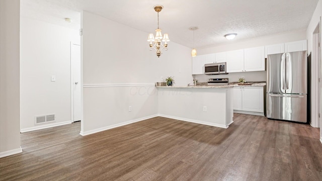 6706 Axtel Dr Unit 7A, Canal Winchester, OH 43110 - kitchen featuring stainless steel appliances, white cabinetry, dark wood finished floors, a peninsula, and a textured ceiling