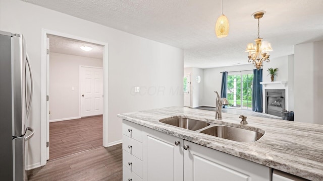 6706 Axtel Dr Unit 7A, Canal Winchester, OH 43110 - kitchen with freestanding refrigerator, a sink, white cabinets, dark wood-type flooring, and hanging light fixtures