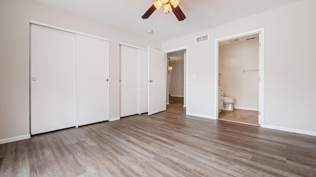 6706 Axtel Dr Unit 7A, Canal Winchester, OH 43110 - unfurnished bedroom featuring multiple closets, wood finished floors, ensuite bathroom, baseboards, and a ceiling fan