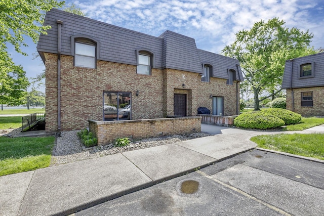 625 Country Club Dr Unit E4, Newark, OH 43055 - view of front facade with mansard roof, brick siding, and uncovered parking