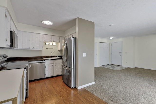 625 Country Club Dr Unit E4, Newark, OH 43055 - kitchen featuring stainless steel appliances, a sink, dark countertops, white cabinetry, and baseboards