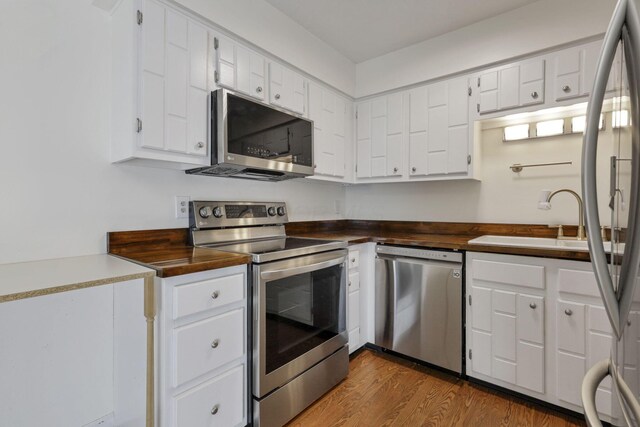 625 Country Club Dr Unit E4, Newark, OH 43055 - kitchen featuring appliances with stainless steel finishes, a sink, wood finished floors, and white cabinetry