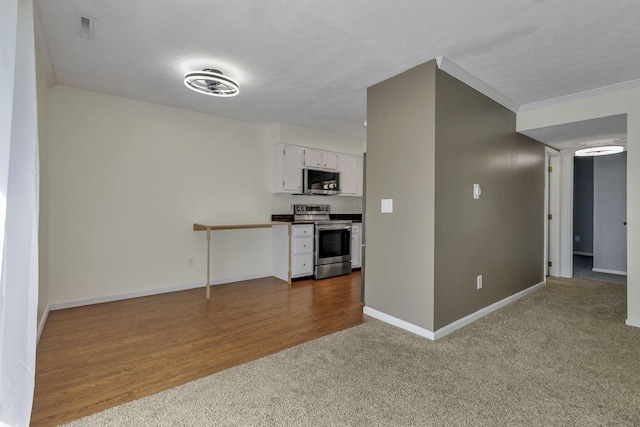 625 Country Club Dr Unit E4, Newark, OH 43055 - kitchen featuring stainless steel appliances, dark colored carpet, baseboards, white cabinetry, and ornamental molding
