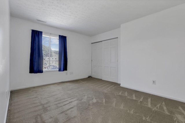 625 Country Club Dr Unit E4, Newark, OH 43055 - unfurnished bedroom featuring carpet flooring, baseboards, a closet, and a textured ceiling