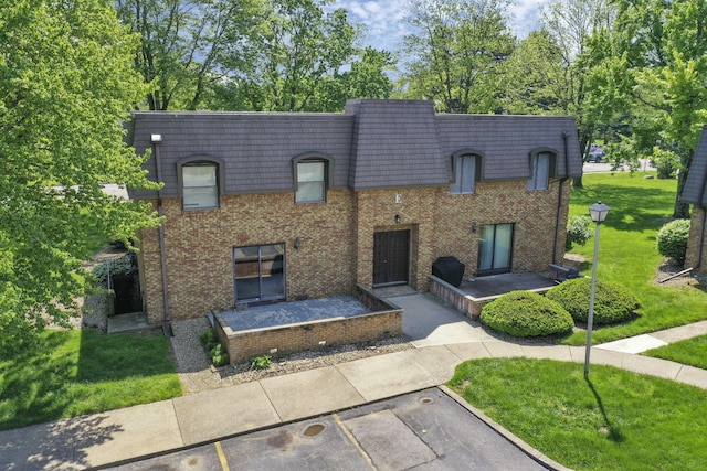 625 Country Club Dr Unit E4, Newark, OH 43055 - view of front facade with mansard roof, a front lawn, brick siding, and uncovered parking