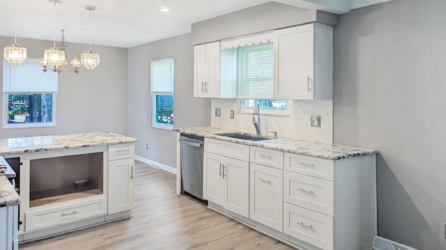 1236 Lindenwood Rd N, Columbus, OH 43229 - kitchen featuring stainless steel dishwasher, a sink, white cabinetry, a chandelier, and decorative backsplash