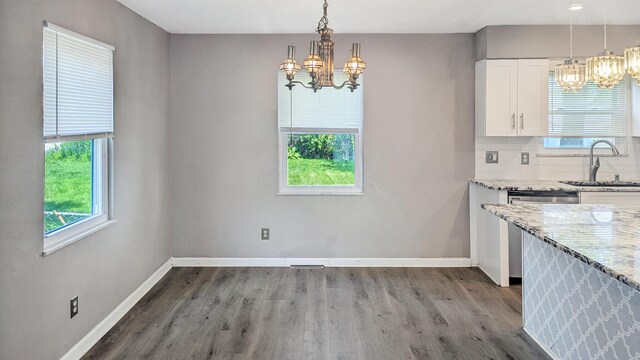 1236 Lindenwood Rd N, Columbus, OH 43229 - unfurnished dining area featuring a chandelier, a sink, healthy amount of natural light, and wood finished floors