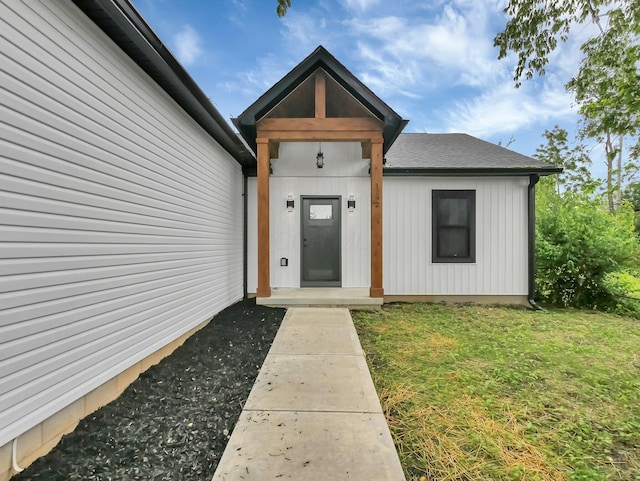1292 Moundview Ave, Columbus, OH 43207 - view of exterior entry with a yard and roof with shingles