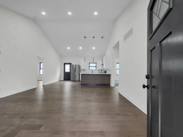 1292 Moundview Ave, Columbus, OH 43207 - unfurnished living room featuring high vaulted ceiling, plenty of natural light, dark wood finished floors, baseboards, and recessed lighting