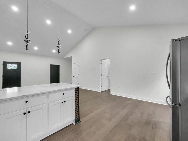 1292 Moundview Ave, Columbus, OH 43207 - kitchen with freestanding refrigerator, white cabinets, light stone countertops, recessed lighting, and wood finished floors