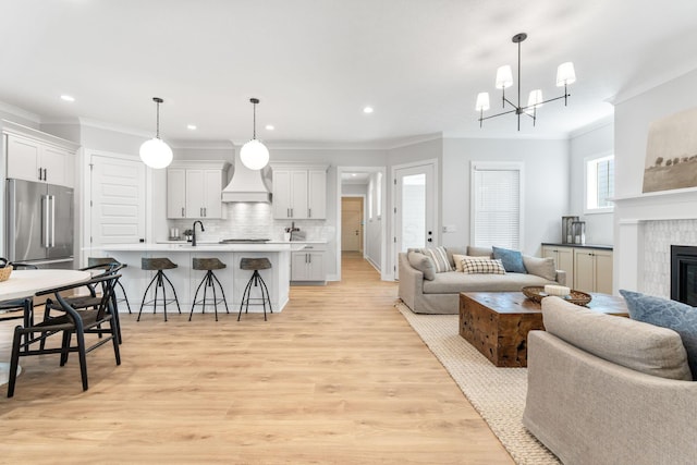 5599 Piatt Rd, Lewis Center, OH 43035 - living area with ornamental molding, recessed lighting, a fireplace, light wood-type flooring, and a chandelier