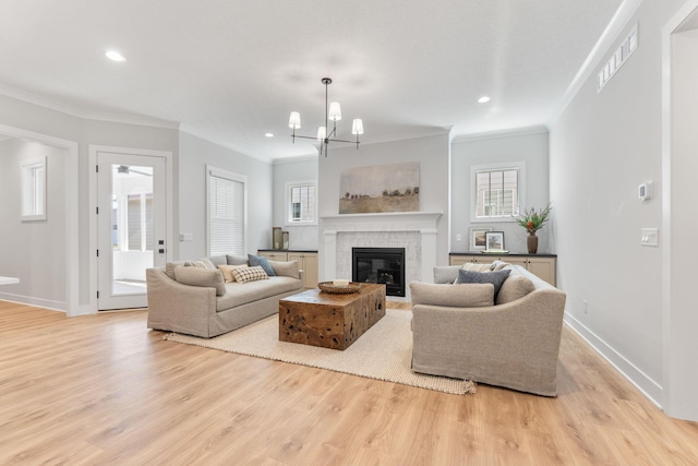 5599 Piatt Rd, Lewis Center, OH 43035 - living area featuring ornamental molding, light wood-style floors, plenty of natural light, a glass covered fireplace, and recessed lighting