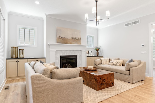 5599 Piatt Rd, Lewis Center, OH 43035 - living room with light wood-style flooring, ornamental molding, a glass covered fireplace, a chandelier, and recessed lighting