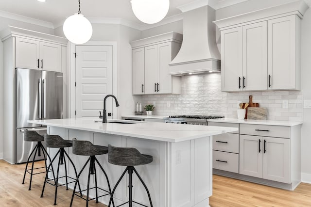 5599 Piatt Rd, Lewis Center, OH 43035 - kitchen featuring freestanding refrigerator, a kitchen bar, custom exhaust hood, a center island with sink, and crown molding