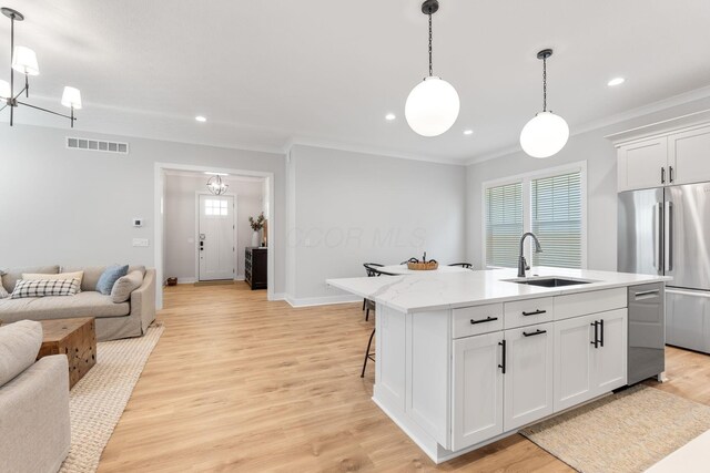 5599 Piatt Rd, Lewis Center, OH 43035 - kitchen featuring open floor plan, stainless steel appliances, crown molding, white cabinetry, and decorative light fixtures