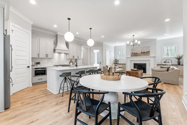 5599 Piatt Rd, Lewis Center, OH 43035 - dining room featuring ornamental molding, recessed lighting, a glass covered fireplace, light wood-style floors, and a chandelier