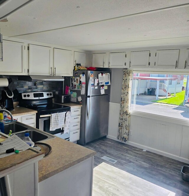 12030 Holly Dr Unit 31, Lakeview, OH 43331 - kitchen with appliances with stainless steel finishes, a sink, light wood-type flooring, white cabinetry, and under cabinet range hood